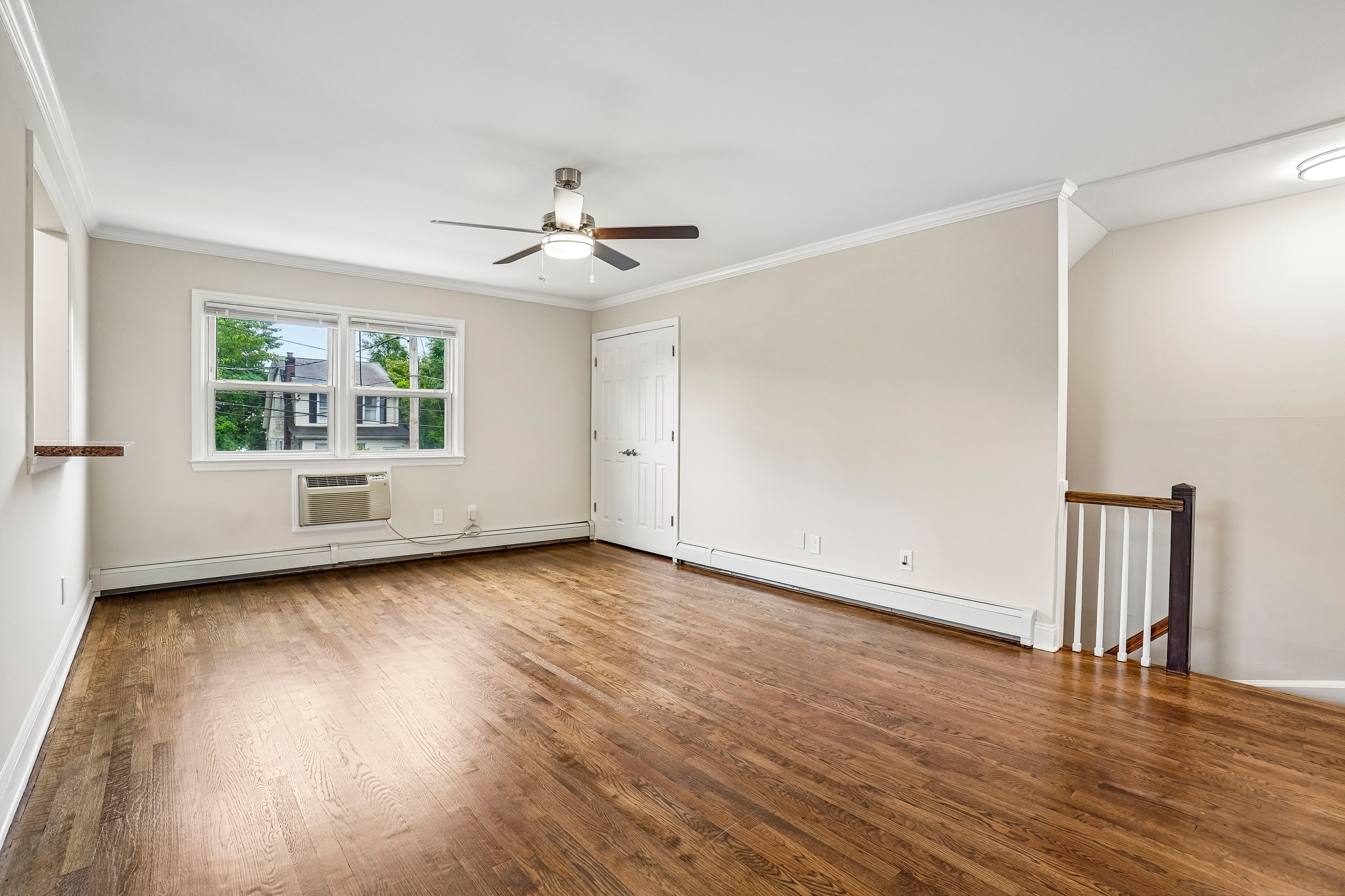 A room with a ceiling fan and a window.